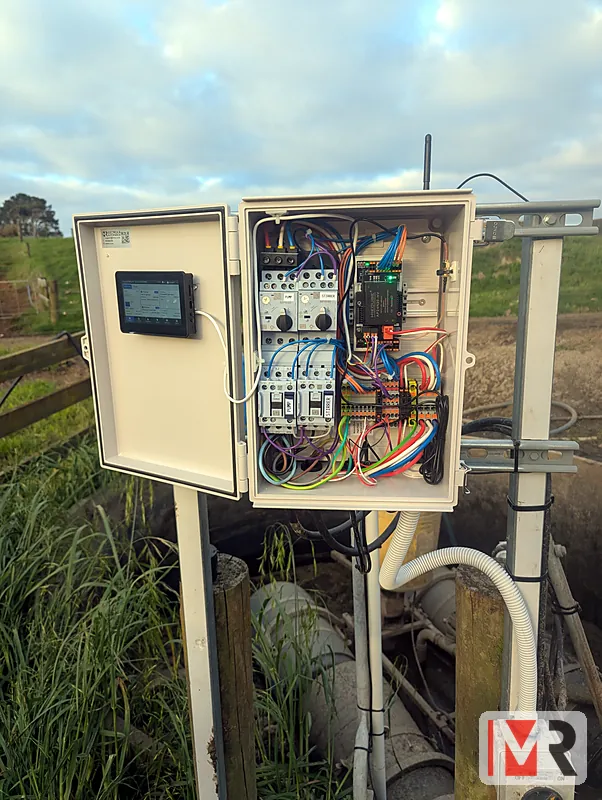 A ModBee pump controller on a post beside farm pipework